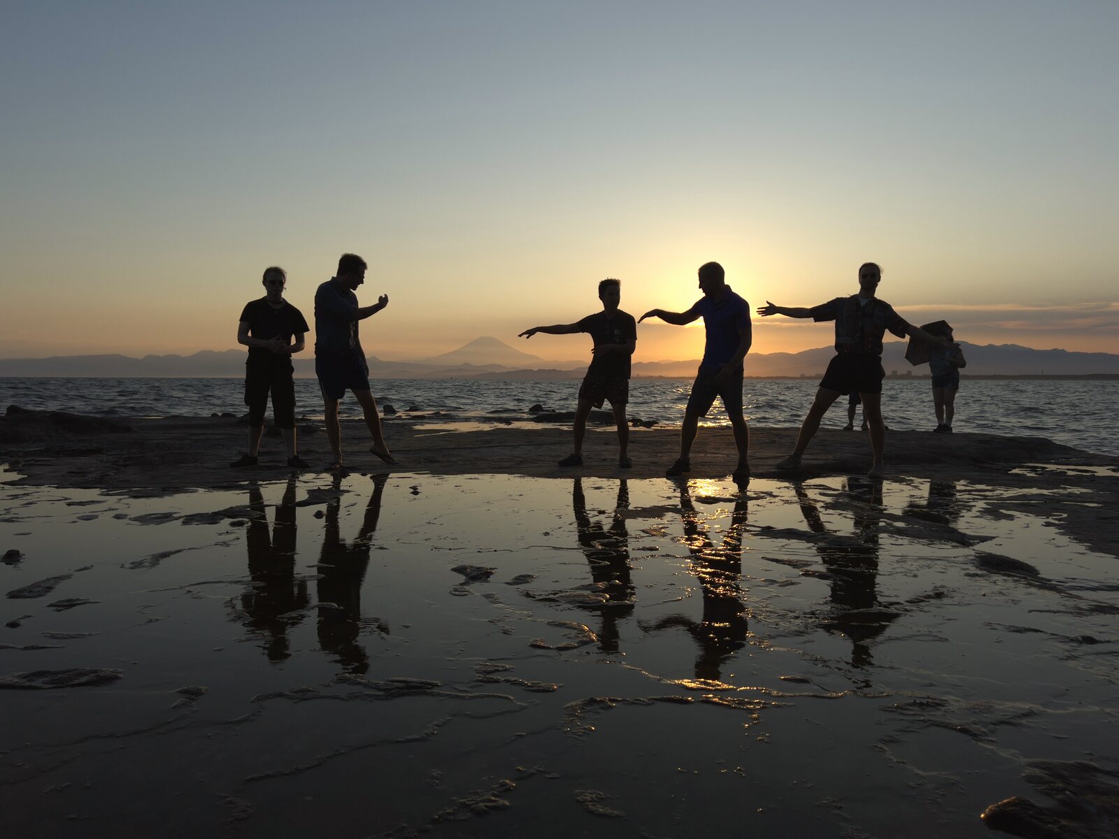Silhouettes of men at sunset on the beach