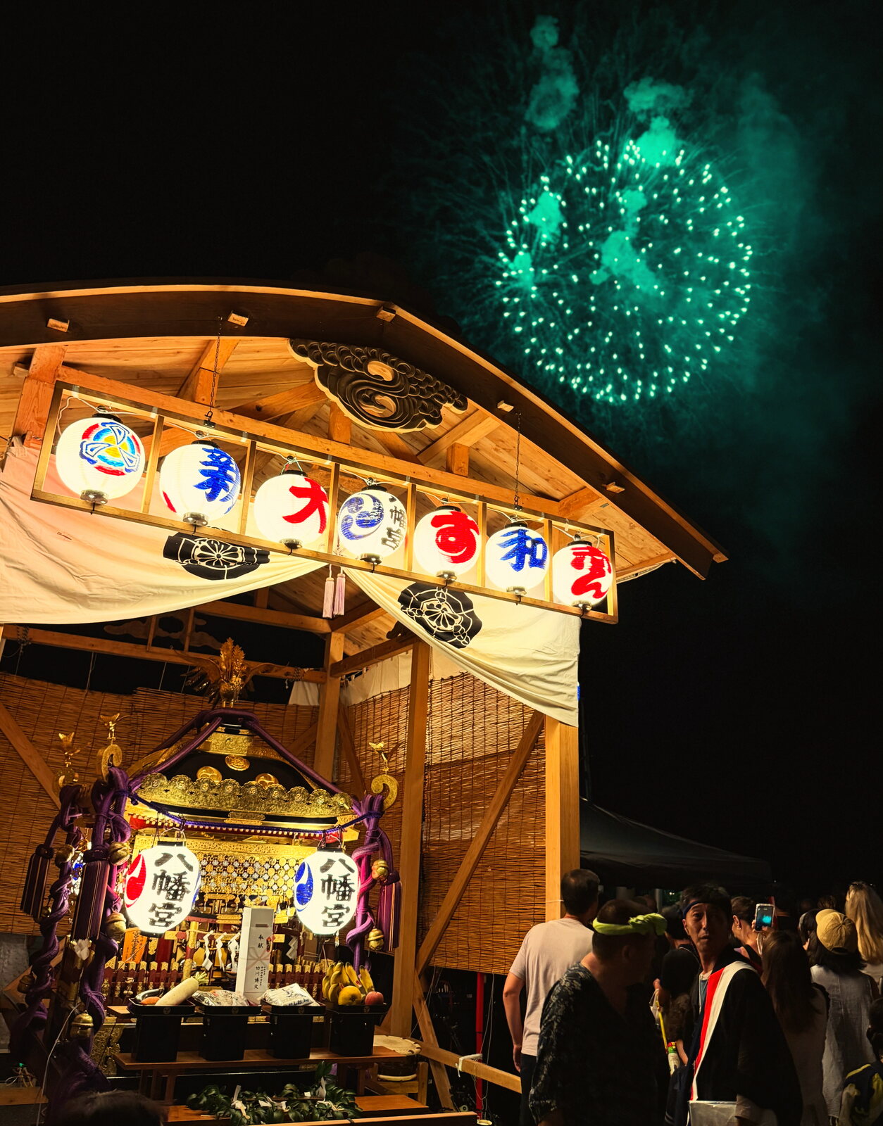 Japanese festival float under fireworks at night