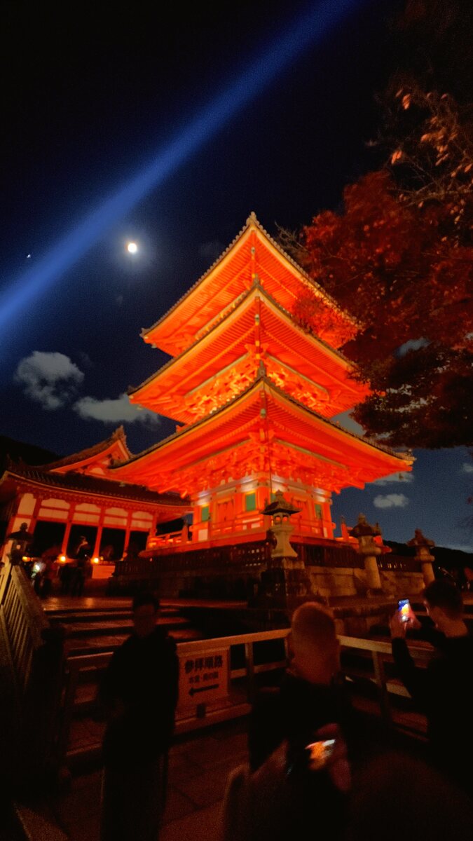 Pagoda lit at night with a beam of light