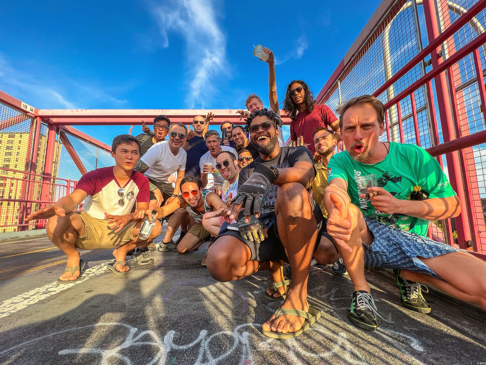 Summit group gathered on a bridge, laughing in the sun
